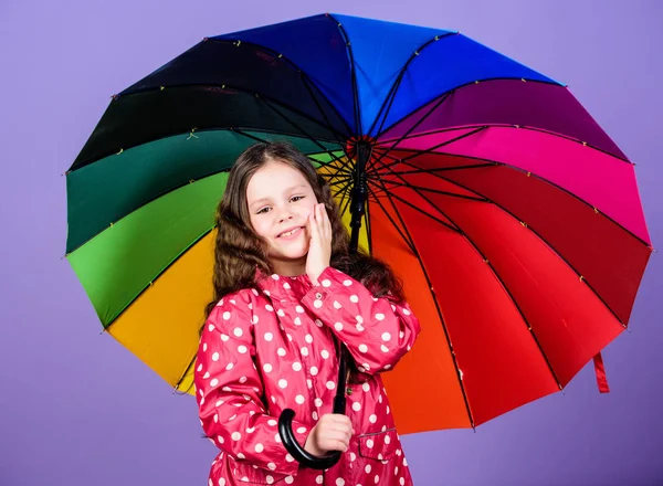 Holčička v pláštěnce. šťastné děvčátko s barevným deštníkem. ochranu proti dešti. Rainbow. podzimní módy. Veselé hipsterové dítě v dobré náladě. Vychutnávání její svobody — Stock fotografie
