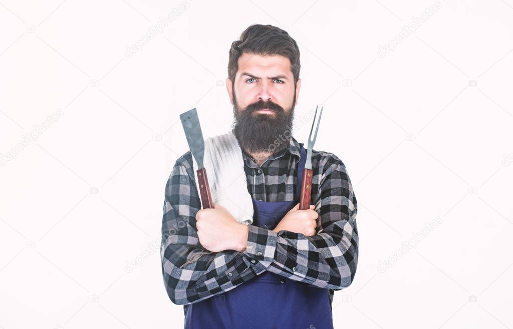 Roasting and grilling food. Man hold cooking utensils barbecue. Tools for roasting meat outdoors. Picnic and barbecue. Cooking meat in park. Masculine hobby. Bearded hipster wear apron for barbecue