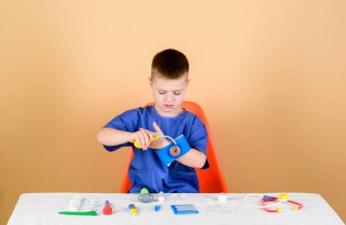 Tıbbi muayene. Tıp eğitimi. Oyun oyna. Çocuk sevimli çocuk gelecek doktor kariyer. Sağlıklı bir hayat. Sağlık. Çocuk küçük doktor steteskop ve tıbbi aletlerle masaya otursun. Tıp kavramı