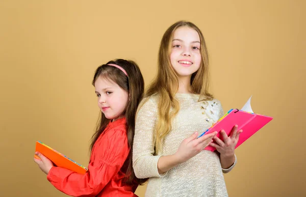 Kleine meisjes met notitieboeken. Vriendschap en zusterschap. werkmappen voorschrijven. Terug naar school. studenten die een boek lezen. School project. gelukkige kleine kinderen klaar voor school les. Hard studeren — Stockfoto