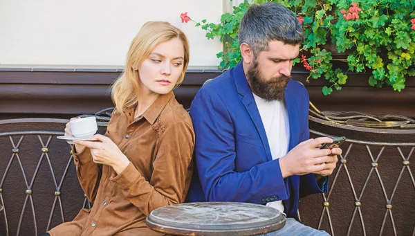 A manhã começa com café e Internet. mulher e homem com barba relaxar no café. Primeiro encontro de raparigas e homens. Casal apaixonado tem problemas. Café da manhã. hipster barbudo usar telefone, menina beber café — Fotografia de Stock