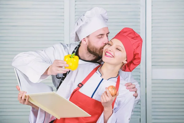 Real love. vegetarian. cook uniform. Dieting vitamin. culinary. happy couple in love with health food. man and woman chef in restaurant. Family cooking in kitchen. man kiss woman with sweet pepper