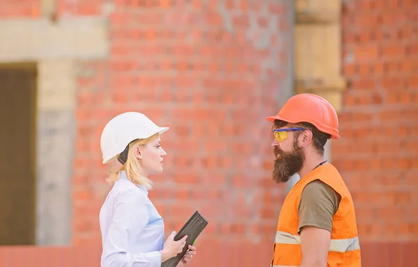 Relationships construction client and participant building industry. Discuss progress plan. Construction industry concept. Woman engineer and bearded brutal builder discuss construction progress