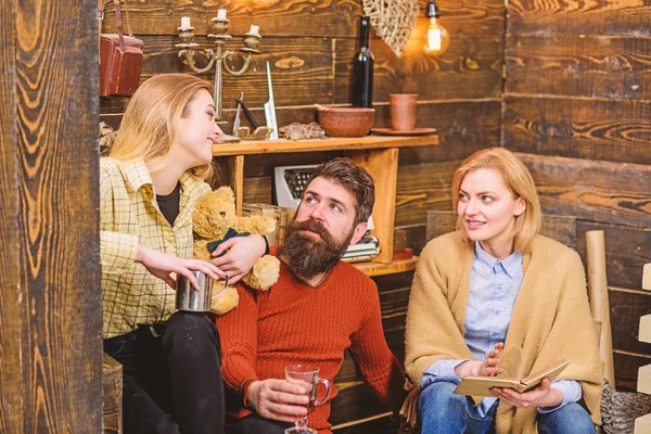 Familia sentados juntos en el sofá en la noche de invierno, concepto acogedor. Padres teniendo una charla encantadora con su hija. Chica rubia hablando con su mamá y su papá. Hombre barbudo pasando tiempo con su familia —  Fotos de Stock