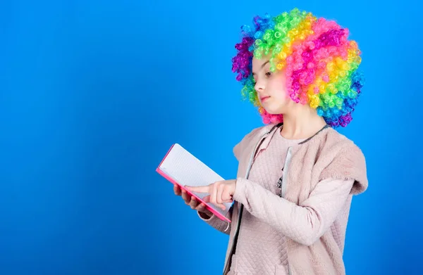 Het lezen van grappen. Tijd om plezier te hebben. Circus school. Studeren hard. Belachelijk verhaal. Lezen van grappig boek. Literatuur Club. Jokes boek concept. Kid kleurrijke krullend pruik kunstmatige haar clown stijl Hold boek — Stockfoto