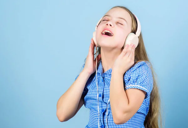 Music is what her feelings sound like. Small child enjoy electronic sound playing in earphones. Little girl relaxing with melodious sound. Cute kid listening to sound track in headphones, copy space — Stock Photo, Image