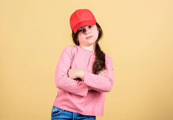 Cutie em boné. Moda moderna. Um acessório elegante. Moda infantil. Sentindo-se confiante com este boné. Menina bonito criança usar boné ou snapback chapéu bege fundo. Menina vestindo boné de beisebol brilhante — Fotografia de Stock