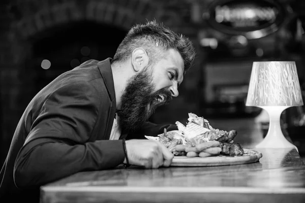 Cheat meal concept. Hipster hungry eat pub fried food. Manager formal suit sit at bar counter. Delicious meal. Man received meal with fried potato fish sticks meat. High calorie snack. Enjoy meal