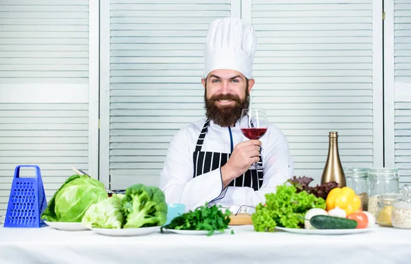 Şarap ve yemek uzmanı gibi maç. Adam şapka ve önlük zevk tat içecek giymek. Usta şef bir kadeh şarap tutar. Biraz alkol ekleyin. Hangi şarap akşam yemeği ile servis. Nefis bir akşam yemeği konsepti. Şarap degustation