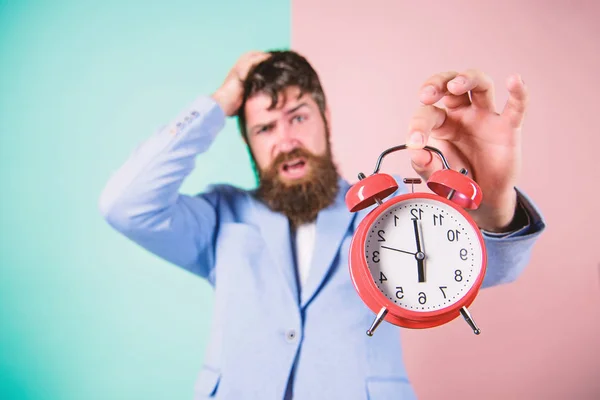 締め切りまでの残り時間。作業する時間。男は髭ストレスの多いビジネスマン ホールド時計です。ストレスの概念。流行に敏感な緊張に満ちた作業スケジュール。ビジネスマンは時間の不足です。時間管理のスキル — ストック写真