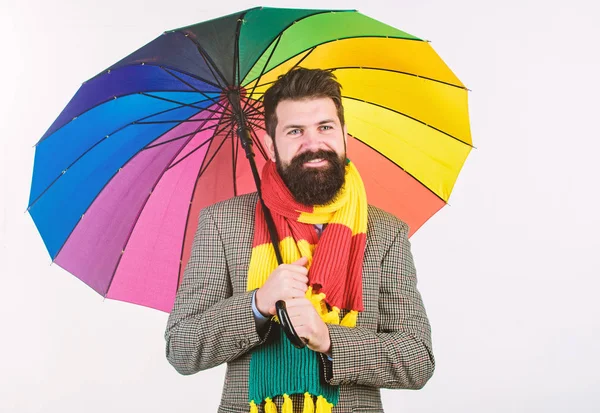 Preparado para o dia chuvoso. Despreocupado e positivo. Aproveite o dia chuvoso. Previsão meteorológica sazonal. Homem barbudo hipster segurar guarda-chuva colorido. Parece estar a chover. Dias chuvosos podem ser difíceis de atravessar — Fotografia de Stock