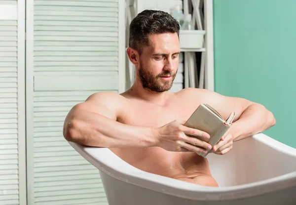 Système nerveux bénéfice baignade. Relax concept. Homme torse musculaire détendre baignoire et lire le livre. gars détendu livre de lecture tout en se relaxant dans un bain chaud. Détends-toi à la maison. Détente totale. Hygiène personnelle — Photo