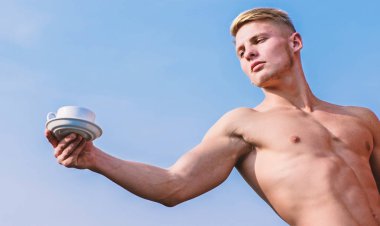 Garson çıplak göğüs kahve fincanı tutun. Seksi gövde çekici garson. Adam kas atlet vücut geliştirmeci kahve sunmaktadır. Maço kas göğüs çıplak gövde tutun fincan taze kahve mavi gökyüzü arka plan