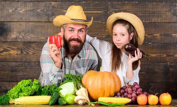 Family farm festival concept. Family father farmer gardener with daughter near harvest vegetables. Man bearded rustic farmer with kid. Countryside family lifestyle. Farm market with fall harvest