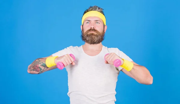 Man bearded athlete exercising dumbbell. Sportsman retro outfit training blue background. Athlete on way to strong body. Healthy habits. Athlete amateur workout. Athlete training with little dumbbell