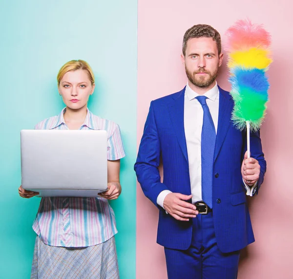 Househusband och kvinnliga chef. Affärsmannen och hemmafru. Familjen par. Man stå med damm borste medan hustru hålla laptop. Par stilig man och vacker kvinna. Städning eller business — Stockfoto