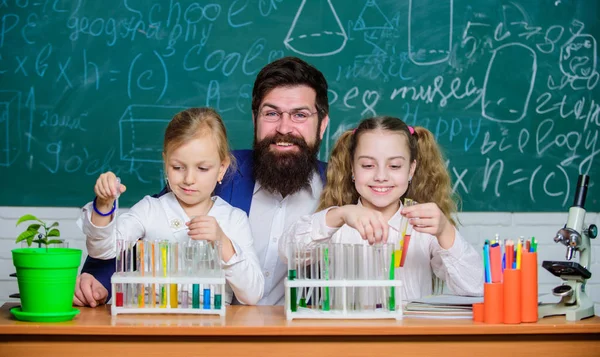 Onderzoeken. Wetenschaps leerkracht en leerlingen die onderzoek verrichten. Leraar en basisschool kinderen houden reageerbuisjes in onderzoek laboratorium. Experimenteel onderzoek voert een laboratoriumtest uit — Stockfoto