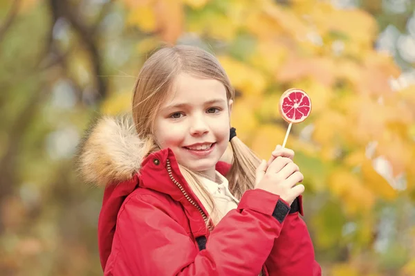 秋の森のお菓子で幸せな小さな女の子。ただの女の子。キャンディ ガール。幸せな子供時代の年。秋になった — ストック写真
