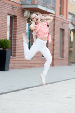 Dans eden tatlı. Sevimli dansçı şehir caddesinde müziğe geçiyor. Küçük çocuk modern müzik le dans etmekten hoşlanır. Enerjik küçük kız zevkle dans ediyor. Dans müziği dinleme