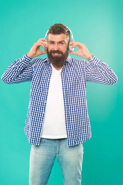 Handsome music lover. Man in headphones. Streaming music sites hippest and hottest around. Wireless technology. User friendly interface and large library of tunes. Hipster with beard listening music — Stock Photo, Image