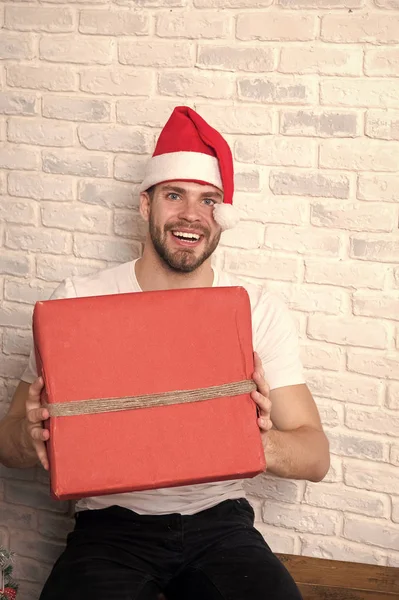 Macho no sorriso chapéu de Natal com presente embrulhado — Fotografia de Stock