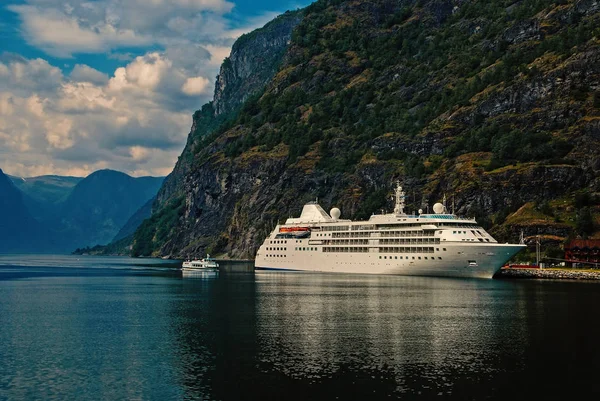 Cruise liner in sea port on mountain landscape in Flam, Norway. Holiday ship in sea harbor with green mountains. Cruise destination and travel. Summer vacation and holiday. Wanderlust and discovery — Stock Photo, Image