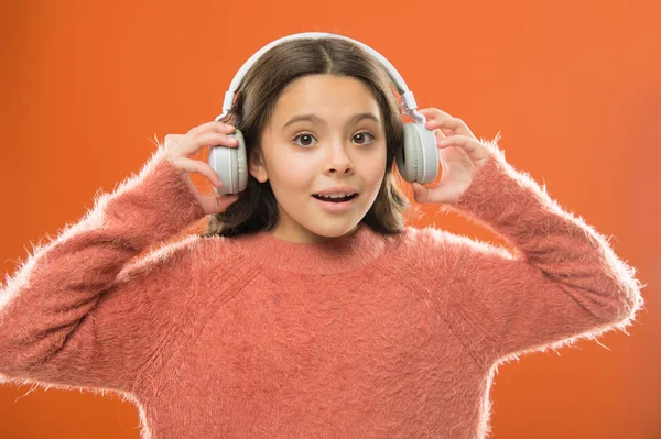 Radio app for your mobile device. Music is her soul. Girl cute little child wear headphones listen music. Kid listen music orange background. Recommended music based on your initial interest — Stock Photo, Image