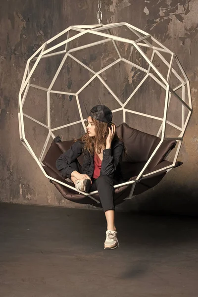 Mulher bonita em boné na cadeira geométrica — Fotografia de Stock