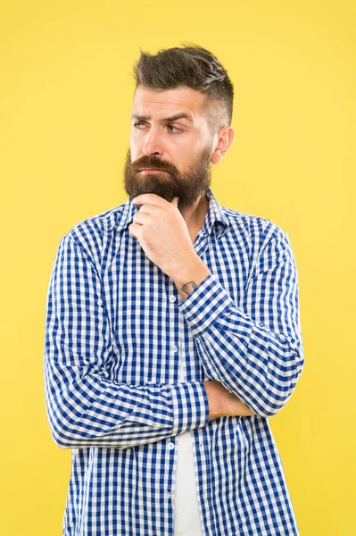 Twijfel. Doordachte uitdrukking. Moet denken. Doordachte man aarzelende besluitvorming. Hipster bebaarde gezicht niet zeker in iets. Doordachte bebaarde man op gele achtergrond close-up — Stockfoto