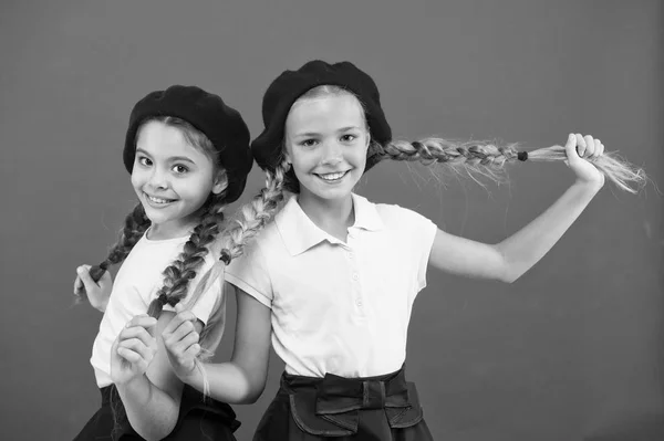 Δικό τους στυλ. Γαλλικό στυλ κορίτσια. Χαριτωμένα κορίτσια που έχουν το ίδιο χτένισμα. Μικρά παιδιά με μακριά μαλλιά πλεξούδες. Κορίτσια της μόδας με δεμένα τα μαλλιά σε πλεξούδες. Παιδάκια φορώντας το κομψό γαλλικό μπερέ — Φωτογραφία Αρχείου