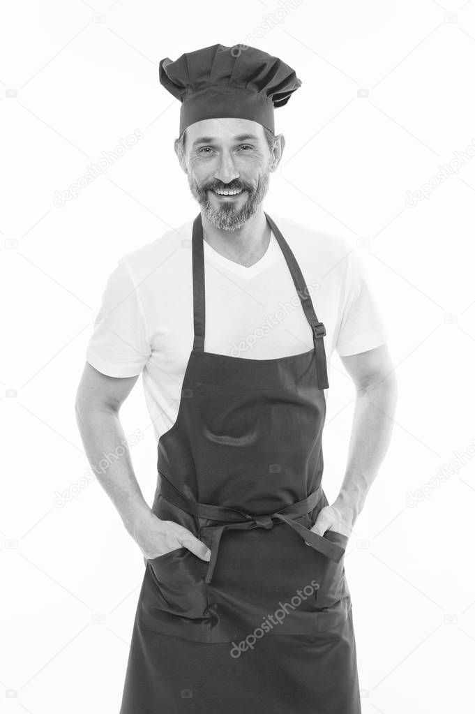 He is a fine hand at cooking. Senior cook with beard and moustache wearing bib apron. Mature chief cook in red cooking apron. Bearded mature man in chef hat and apron. Home cooking