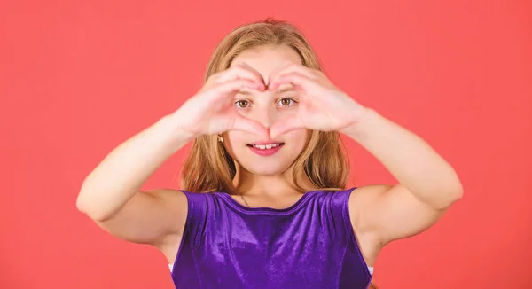 Niña adorable chica con el pelo largo sonriente cara mostrar gesto de corazón para usted. Celebra el día de San Valentín. Amor y simpatía. Concepto de amor. Chica linda niña mostrar gesto de la mano en forma de corazón. Símbolo del amor —  Fotos de Stock