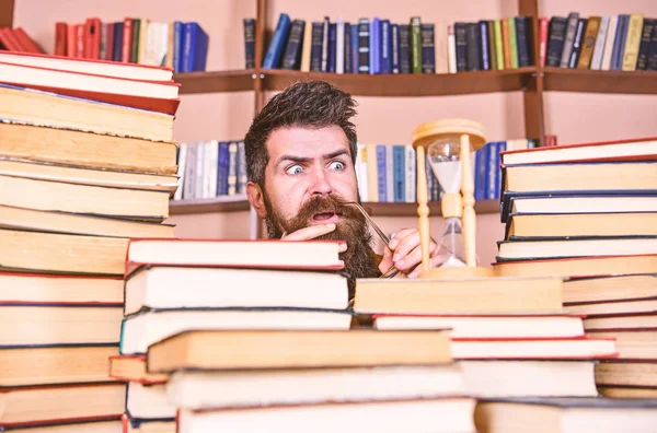 Dostum, bilim adamı kum saati görünüyor. Zaman akışı kavramı. Öğretmen ya da sakal Kitaplığı'nda eğitim ile öğrenci. Adam ciddi ve şok yüz izlerken zaman raflardan, arka planda gidiyor