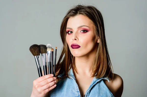 Makeup cosmetics concept. Skin tone concealer. Cosmetics shop. Girl apply eye shadows. Woman applying makeup brush. Emphasize femininity. Professional makeup supplies. Skin care. Different brushes