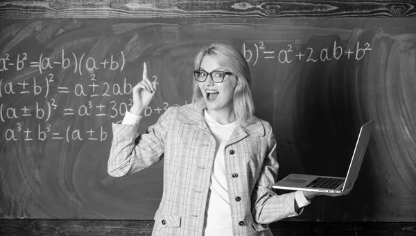 Educator smart clever lady with modern laptop searching information chalkboard background. Online schooling concept. Woman wear eyeglasses holds laptop surfing internet. Educational site for teachers — Stock Photo, Image