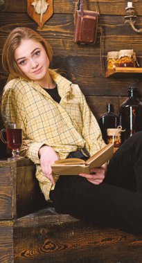 Çalışma kavramı. Ahşap vintage iç kitap ile gündelik kıyafeti kız oturuyor. Bayan kareli giysiler içinde sakin yüzünde sevimli ve rahat görünüyor. Kız öğrenci çalışma kitabı içinde hakem ev ile