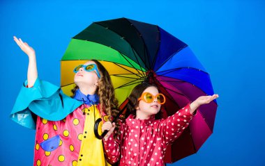 aile bağları. Yağmurluk lu küçük kızlar. renkli şemsiye ile mutlu küçük kızlar. yağmur koruma. Gökkuşağı. sonbahar moda. neşeli hipster çocuklar, kardeşlik. Doğanın güzelliğini hissetmek