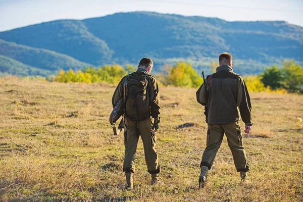 Caça com parceiro fornecer maior segurança medida muitas vezes divertido e gratificante. Caçadores amigos gamekeepers andar montanhas fundo. Caçadores espingardas ambiente natureza. Hunter amigo desfrutar de lazer — Fotografia de Stock