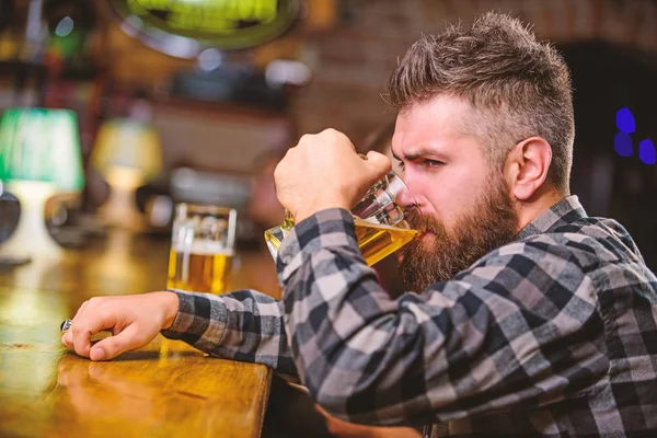 Annak érdekében, hogy alkoholt inni. Bár pedig pihentető italt, és pihenjen. Csípő pihentető a bárban, sör. Férfi szakállal töltenek szabadidős sötét bárban. Brutális csípő szakállas ember ül bár counter sört inni — Stock Fotó