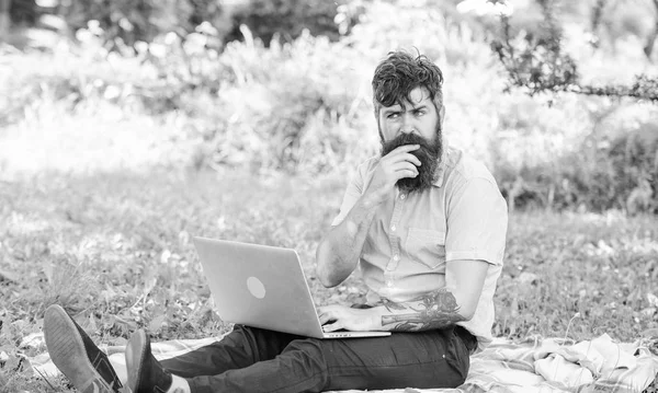 Blogger thoughtful face create content. Hipster blogger with laptop nature background. Blogger create content for social network. Writer or blogger write post for social network. Creativity crisis