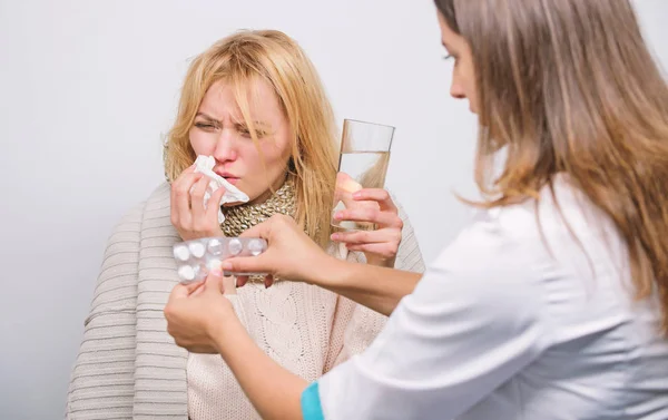 Treating her with medication. Medical doctor examining patient. Primary care doctor making diagnosis to sick woman. Patient care and healthcare. Doctor visiting unhealthy woman at home