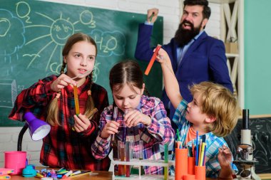 Çocuklar bilimsel deneyler yapıyor. Eğitim. Kimya laboratuvarı. Mutlu çocuk öğretmenim. Okula dönüyorum. Kimya laboratuvarında sıvılarla deneyler yapıyor. Ölümcül ve tehlikeli.