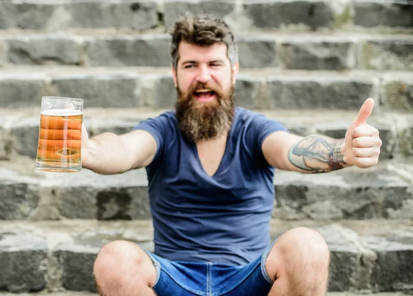 As cervejas claras ou as cervejas escuras bebem todas. Café terraço de verão. Um tipo a descansar com cerveja gelada. Hipster relaxou bebendo cerveja ao ar livre. Homem com barba e bigode segurar vidro de cerveja ao ar livre — Fotografia de Stock