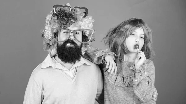 How crazy is your father. Man bearded father and girl wear colorful wig while eat lollipop candy. Thing loving father do for children. Tribute to fun dad. Easy simple ways be fun playful parent