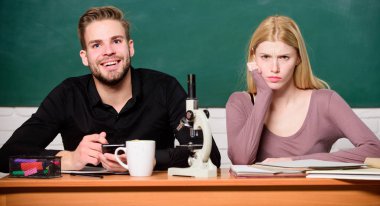 Biyoloji dersi. Üniversite okuyan öğrenciler. Genetik ve mühendislik. Zor bir üniversite konusu. Bilimsel deney. Masadaki mikroskoplu adam ve kız. Üniversitede ya da üniversitede okumak