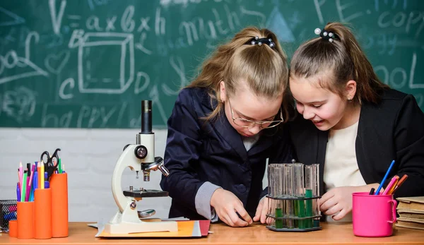 Basic knowledge of chemistry. Pupils cute girls use test tubes with liquids. Chemistry experiment concept. Safety measures for providing safe chemical reaction. Make studying chemistry interesting