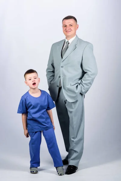 Doctor respectable career. Dad boss. Father and cute small son. Child care development upbringing. Respectable profession. Family business. Man respectable businessman and little kid doctor uniform