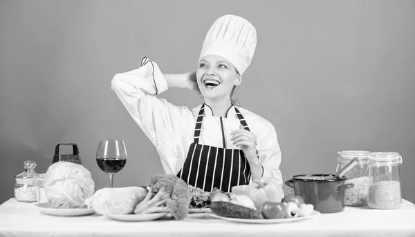 Gourmet main dish recipes. Girl in hat and apron. Delicious recipe concept. Cooking healthy food. Fresh vegetables ingredients for cooking meal. Lets start cooking. Woman chef cooking healthy food