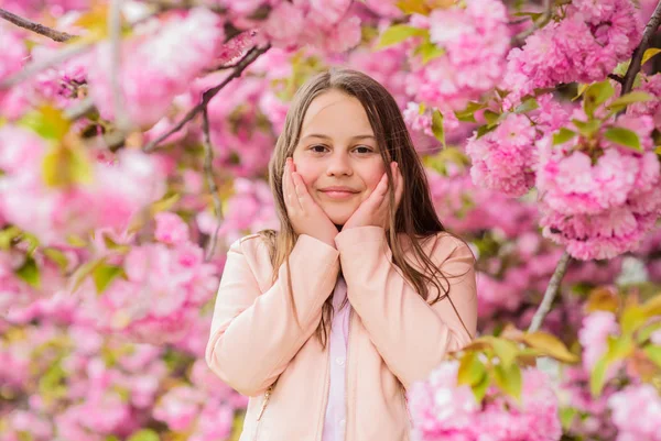 Lekarstwo na alergie. Dziecko cieszyć się życiem bez alergii. Wąchania kwiatów. Dziewczyna ciesząc się kwiatowym aromatem. Koncepcja alergii pyłku. Kid cieszyć Cherry Blossom Sakura. Dziecko na różowe kwiaty Sakura drzewo tło — Zdjęcie stockowe