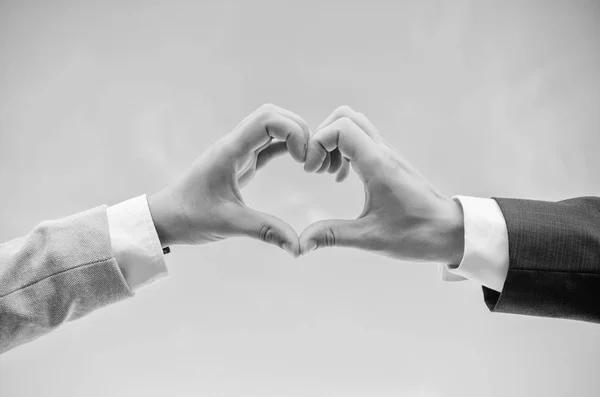 Kézzel szív gesztus formák alakú ujját. Férfi kezét a szív alakú megfelelő kézmozdulat-szimbólum a szeretet és a romantika. Szerelmi szimbólum fogalom. Kéz össze a szív alakú kék ég háttér — Stock Fotó